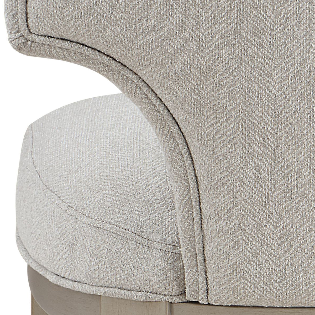 Closeup of a beige upholstered dining chair with a textured woven fabric