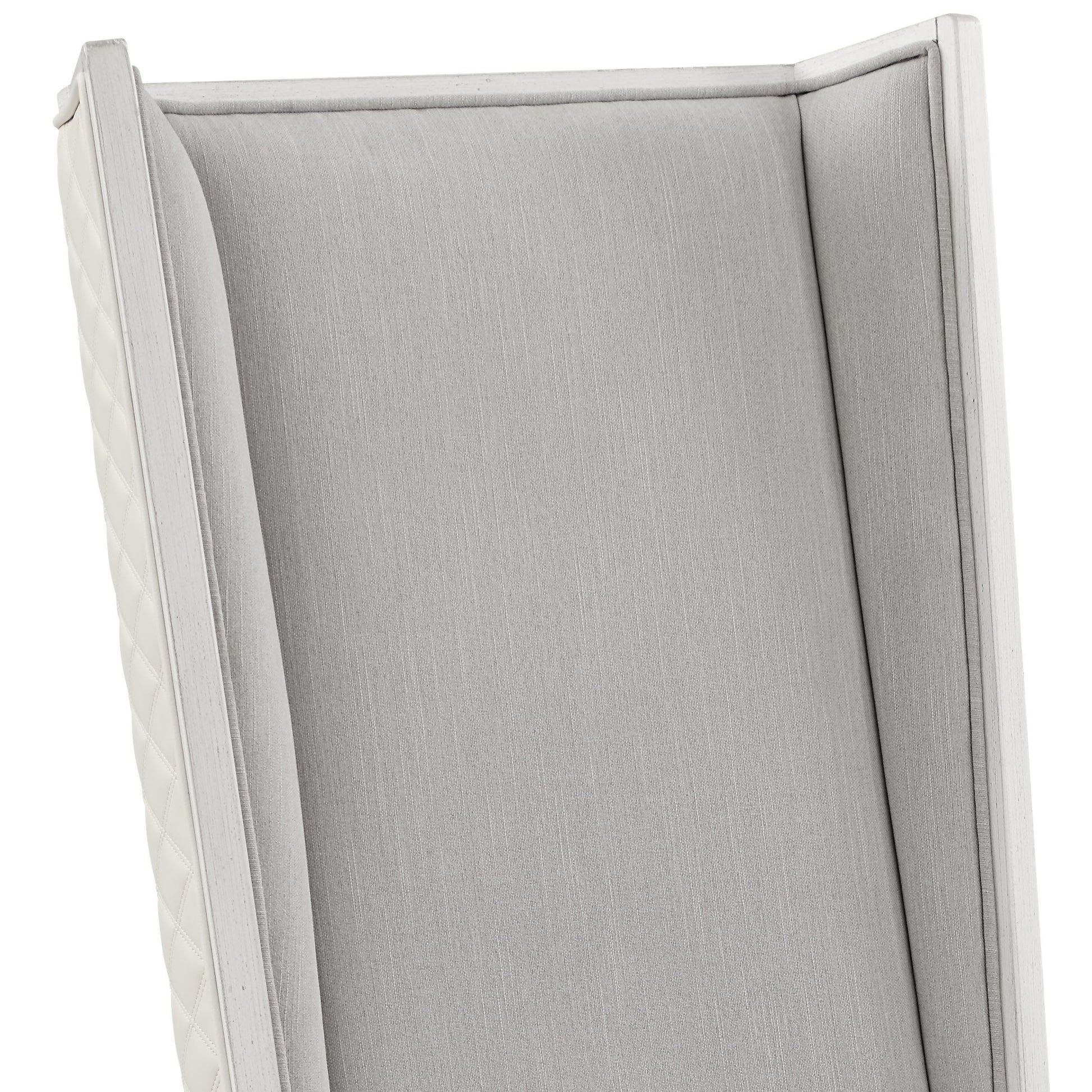 Elegant grey upholstered accent chair with white wooden trim and quilted side panels
