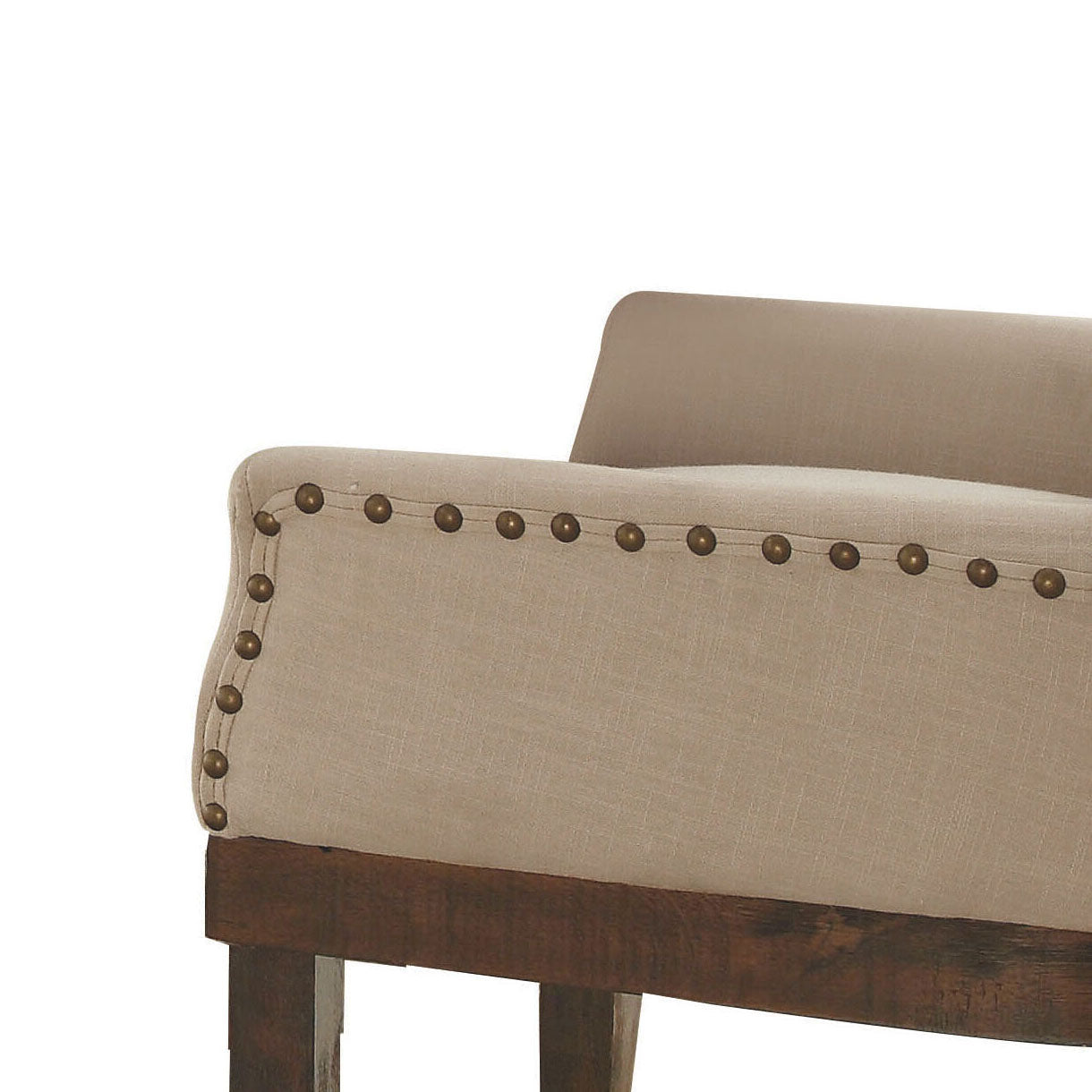 Tufted armrest detail on beige linen accent chair with brass nailhead trim