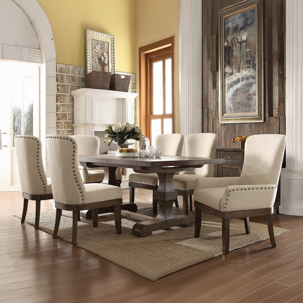 Rustic farmhouse dining table with upholstered chairs and nailhead trim