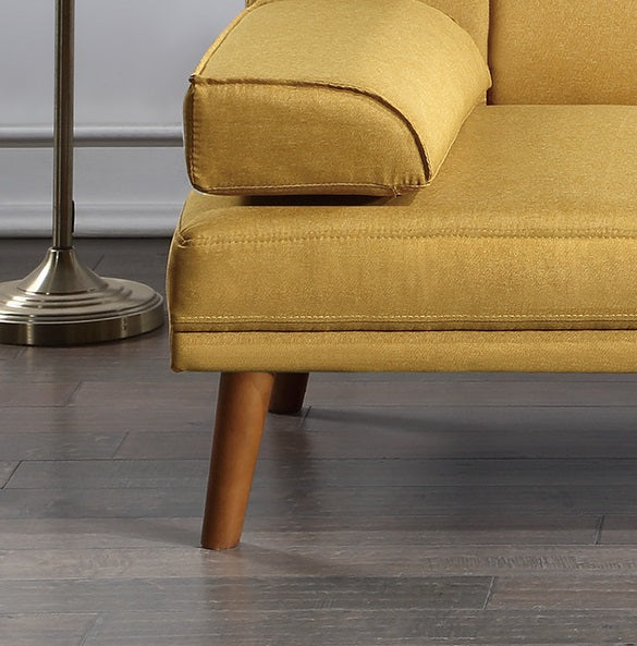 Closeup of mustard yellow upholstered sofa arm with tapered wooden legs