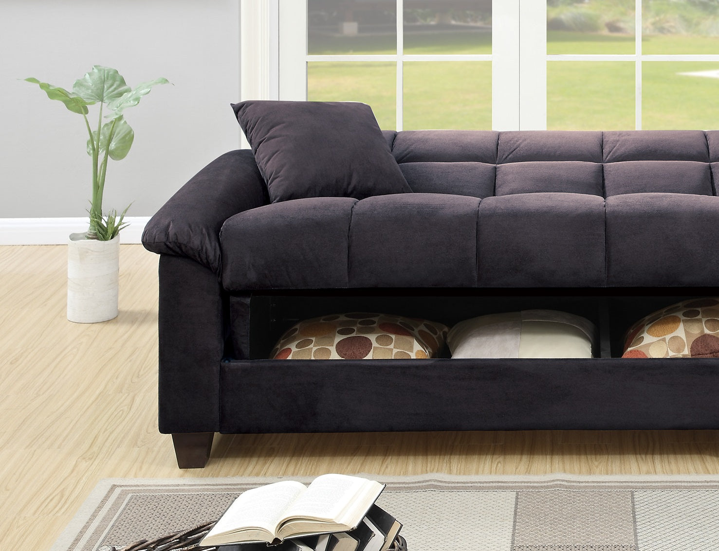 Dark charcoal grey tufted sofa with hidden storage compartment and decorative pillows