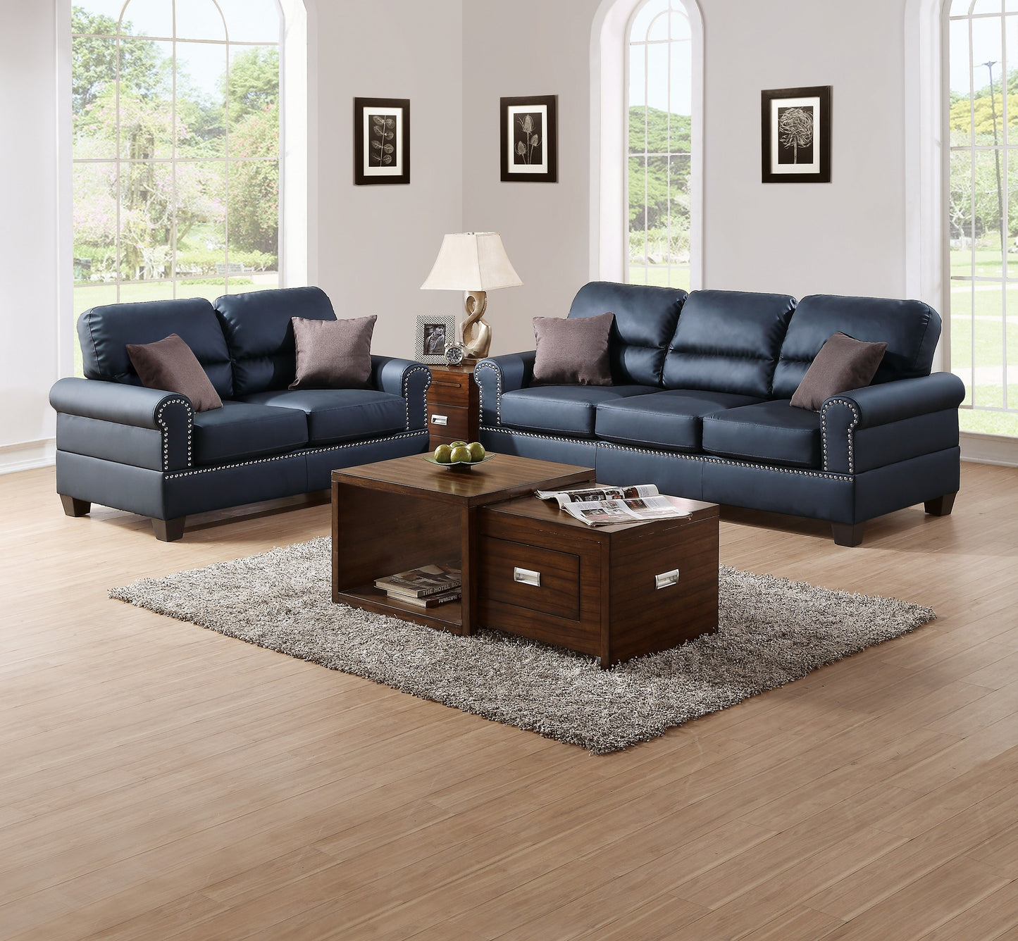 Navy blue leather sofa set with decorative nailhead trim and throw pillows