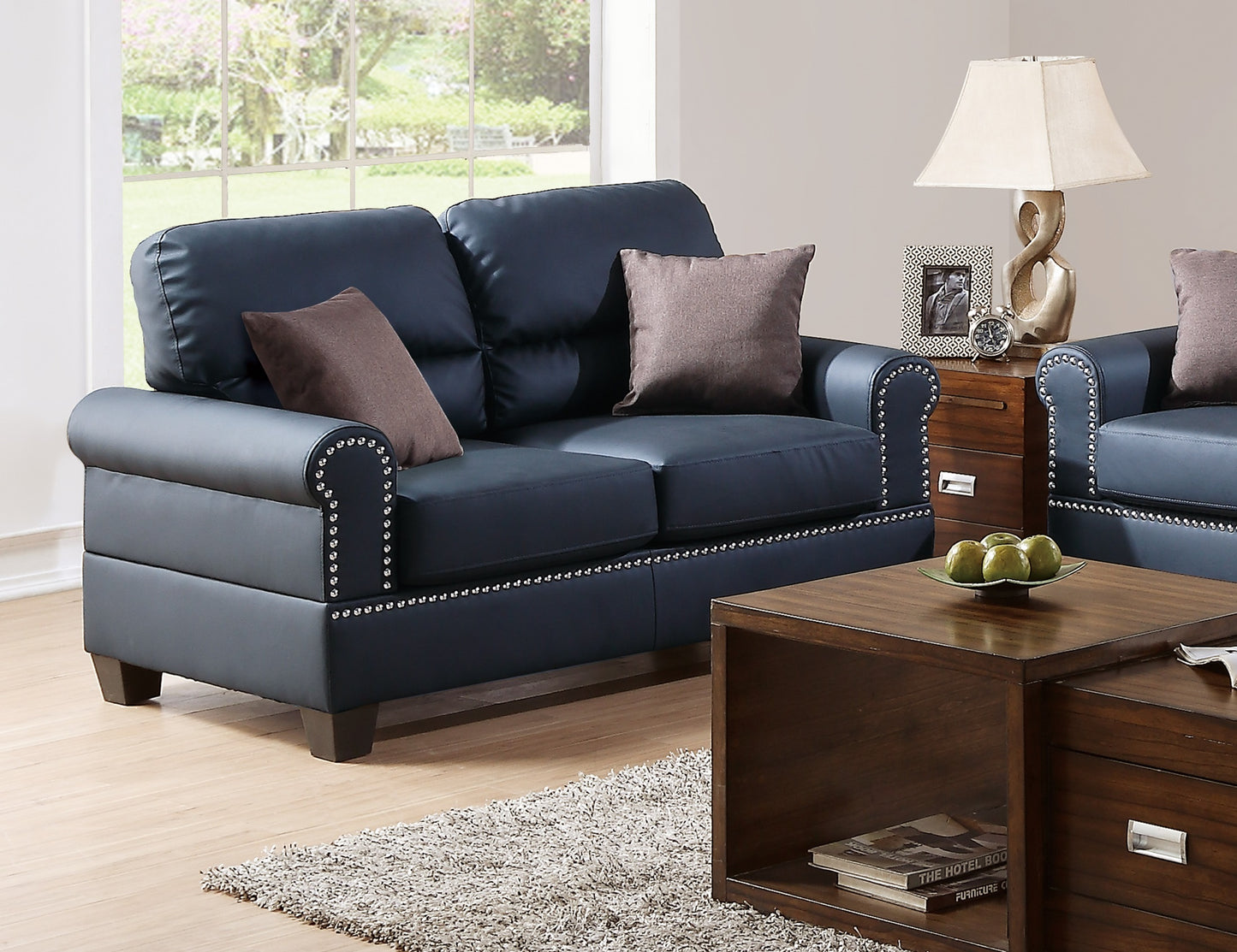 Navy blue leather loveseat with silver nailhead trim and plush cushions perfect for a living room