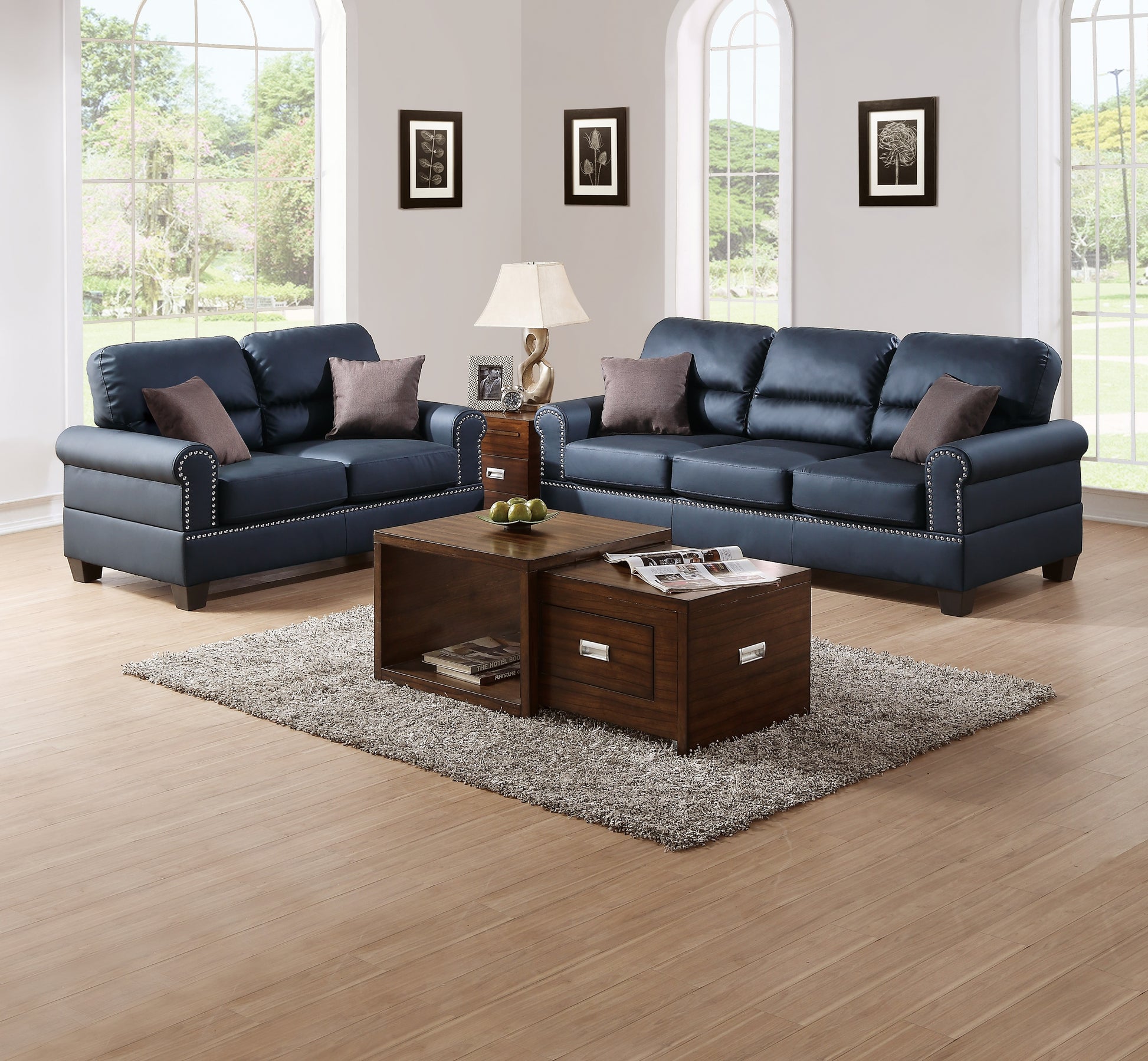 Dark blue faux leather sofa with silver nailhead trim and plush throw pillows