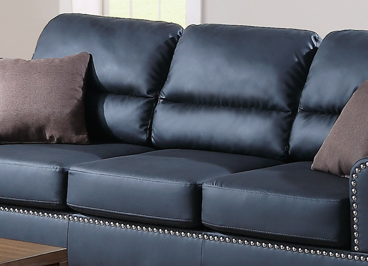 Dark blue faux leather sofa with tufted back cushions and decorative nailhead trim ideal for a modern living room