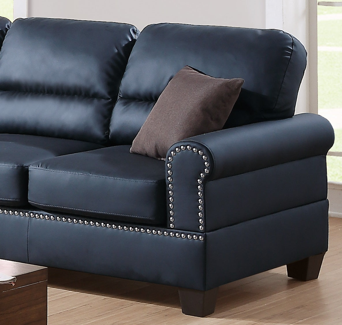 Dark navy leather sofa with elegant nailhead trim on the armrest and base