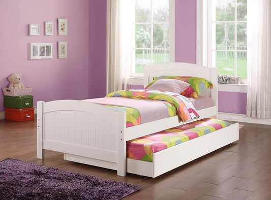 White wooden twin bed with trundle featuring colorful bedding and a plush rug