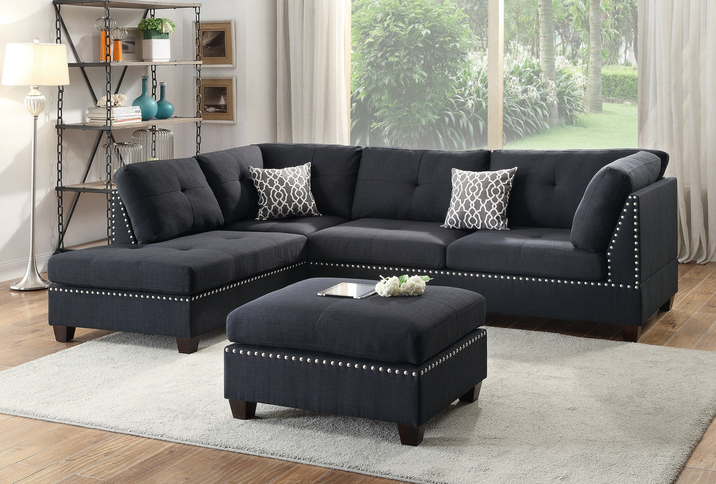 Dark gray tufted sectional sofa with studded trim and patterned pillows