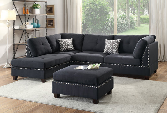 Dark gray tufted sectional sofa with studded trim and patterned pillows