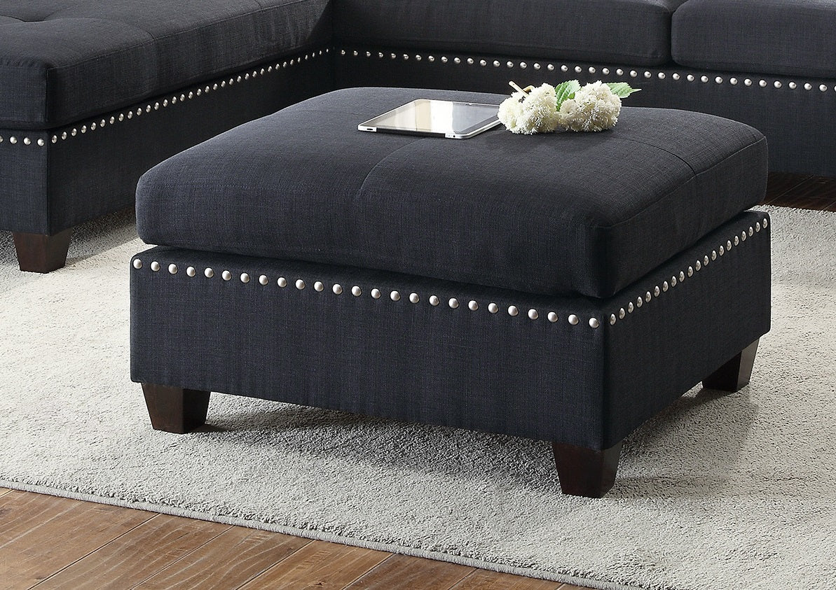 Dark gray upholstered ottoman with silver nailhead trim accenting modern living rooms