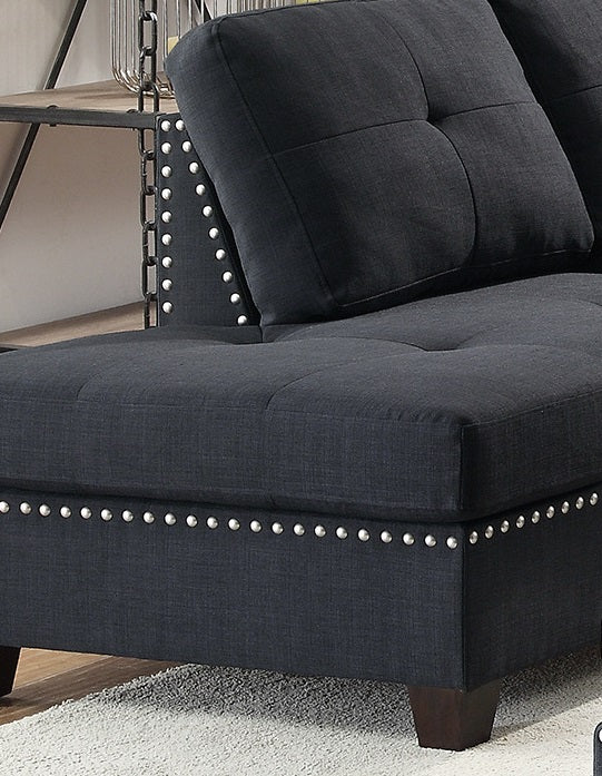 Dark gray fabric sectional sofa with tufted cushions and decorative nailhead trim