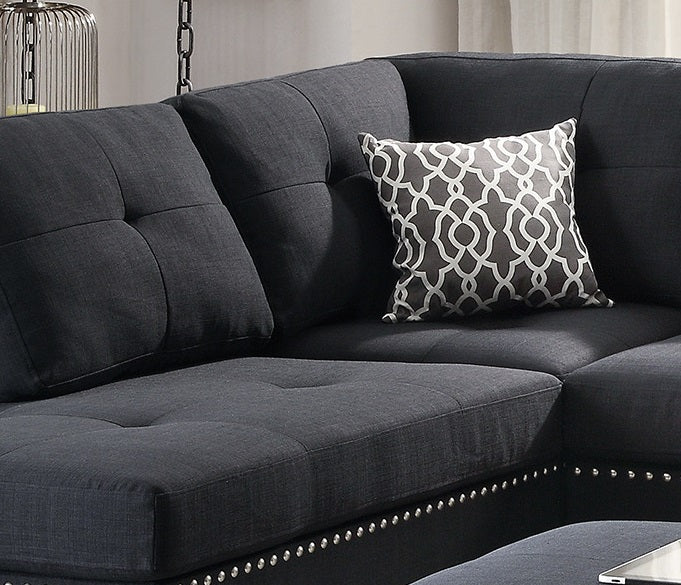 Dark gray sectional sofa with tufted cushions and a decorative throw pillow