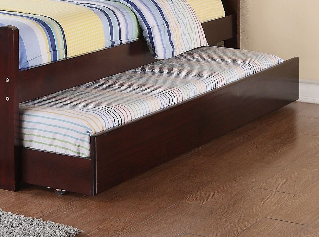 Dark wood trundle bed with striped mattress pulled out from under a bunk