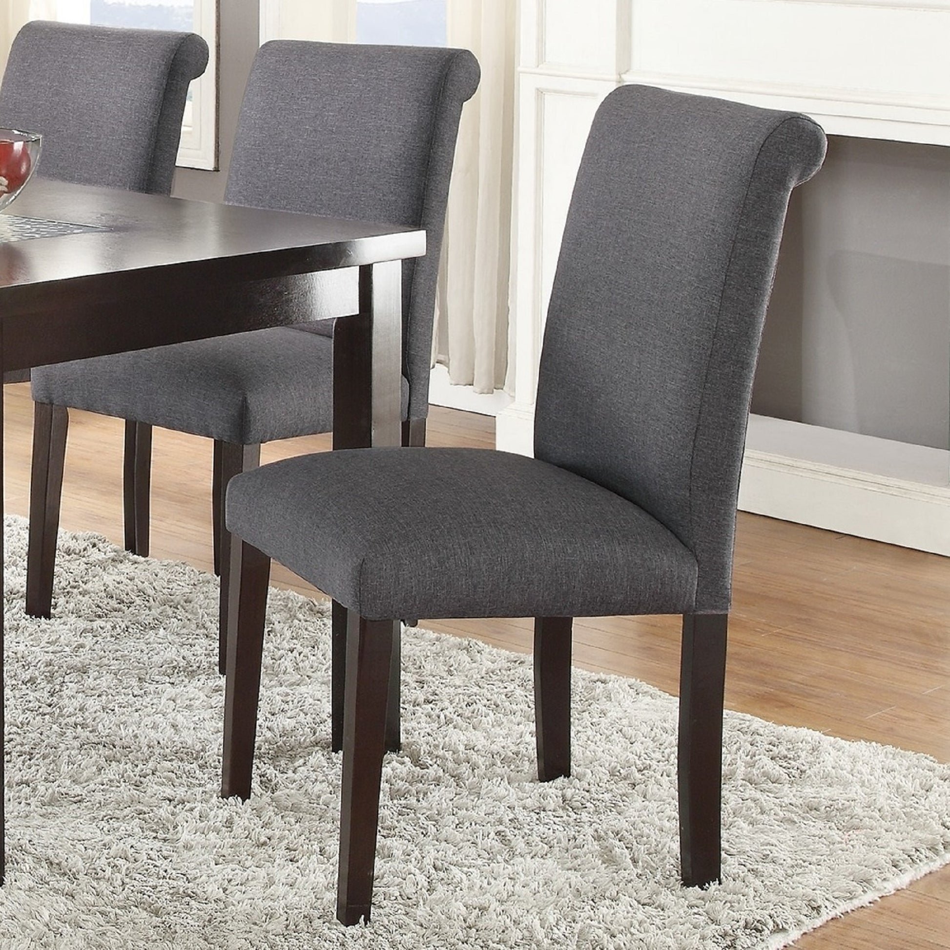 Dark grey upholstered dining chair with curved back and dark wood legs