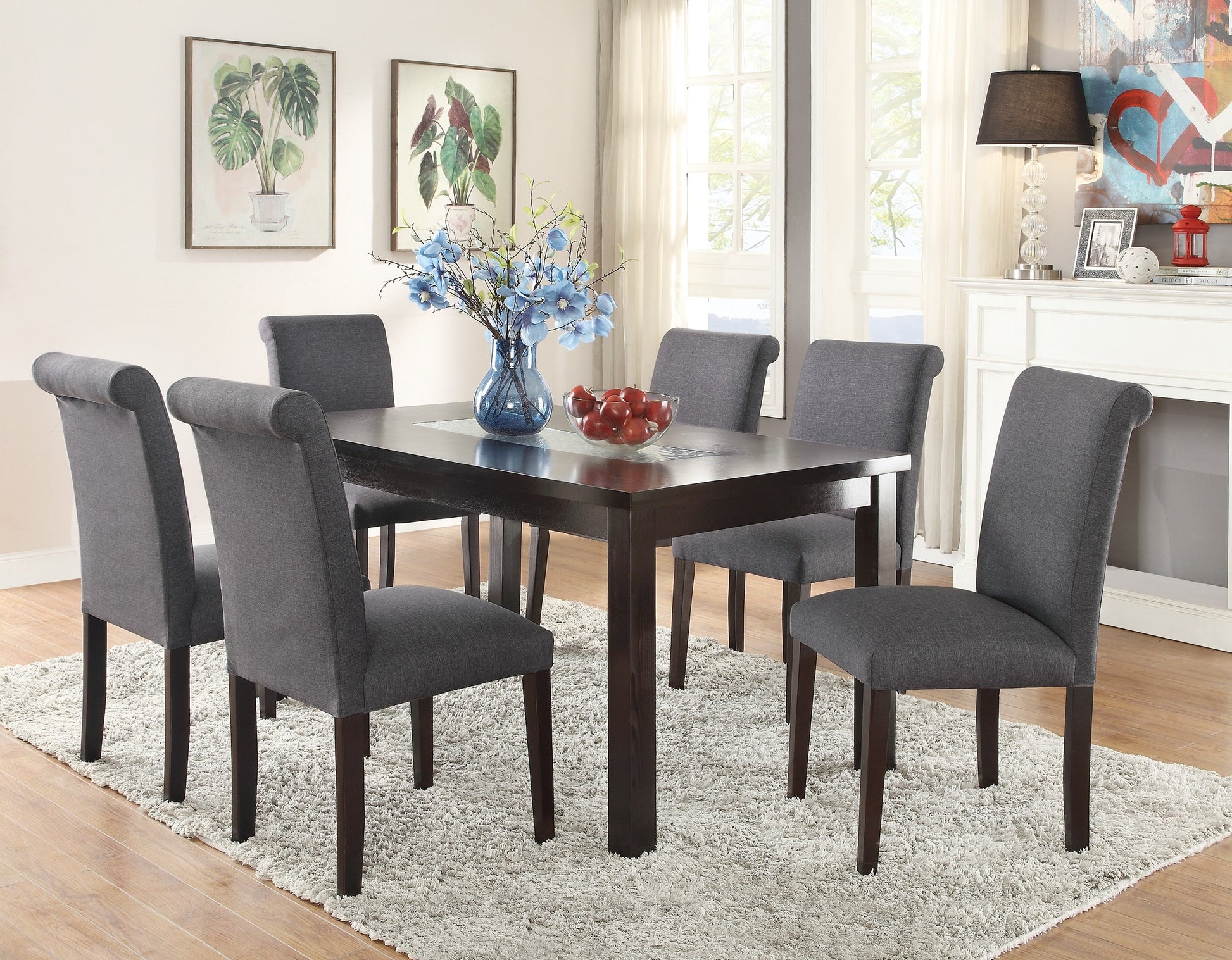 Dark wood dining table with upholstered grey chairs set in a modern dining room