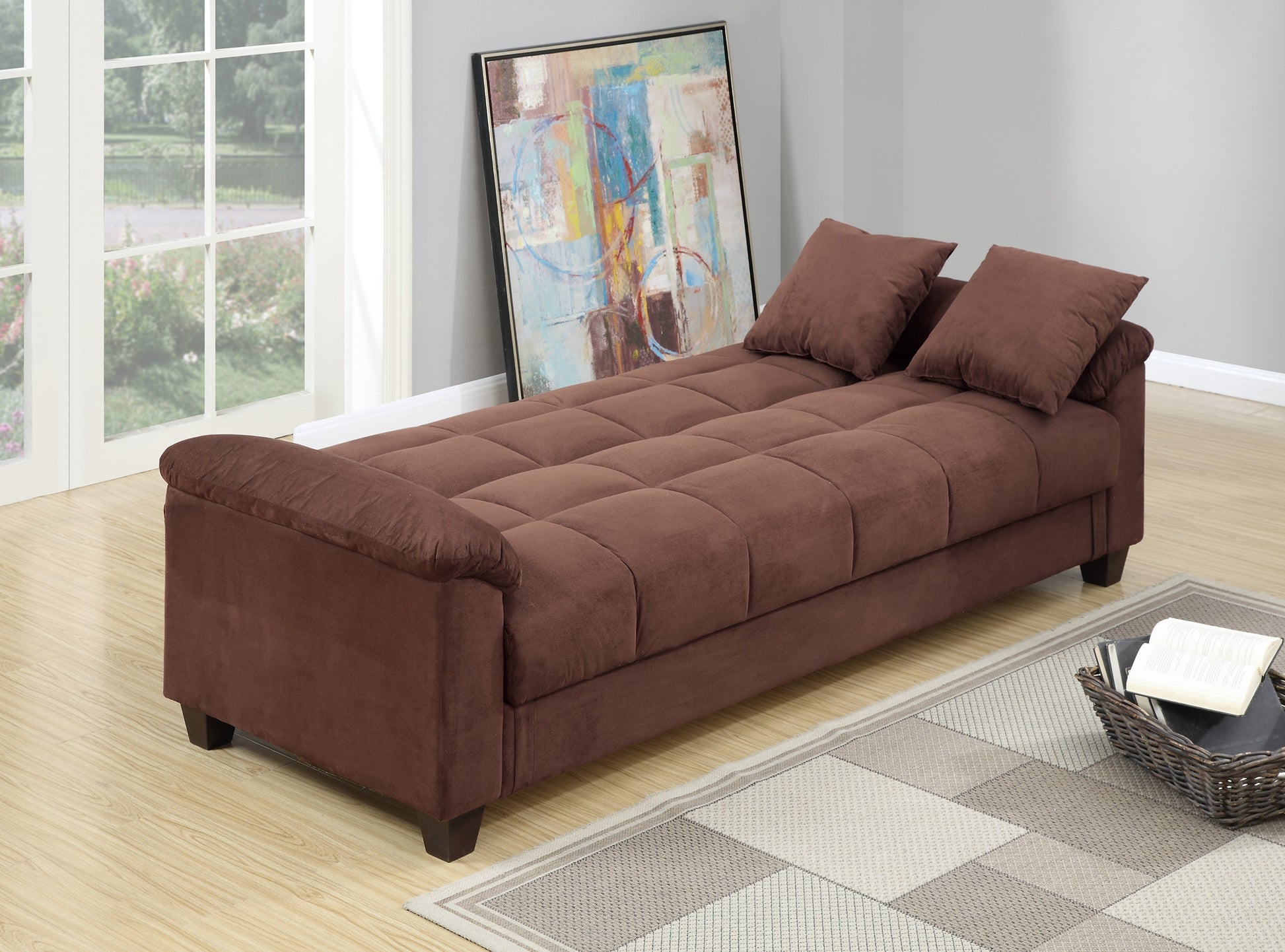 Brown suede futon sofa with tufted seat and two throw pillows for versatile living space