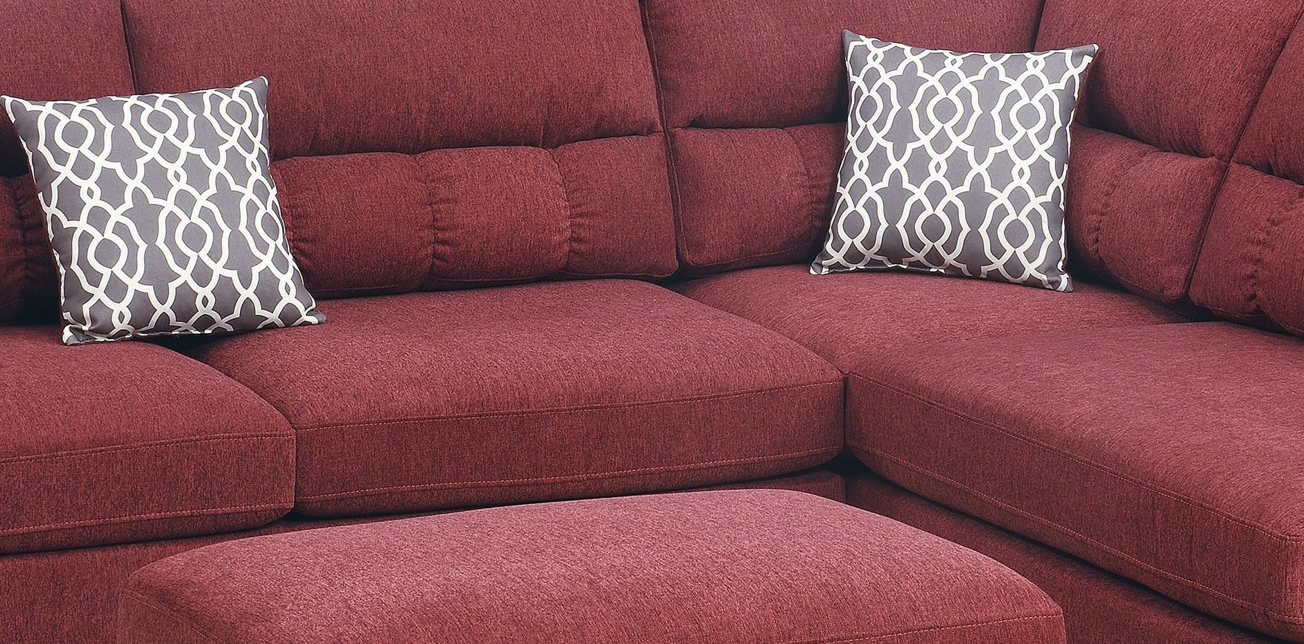 Deep red sectional sofa with diamond pattern accent pillows perfect for a modern living room