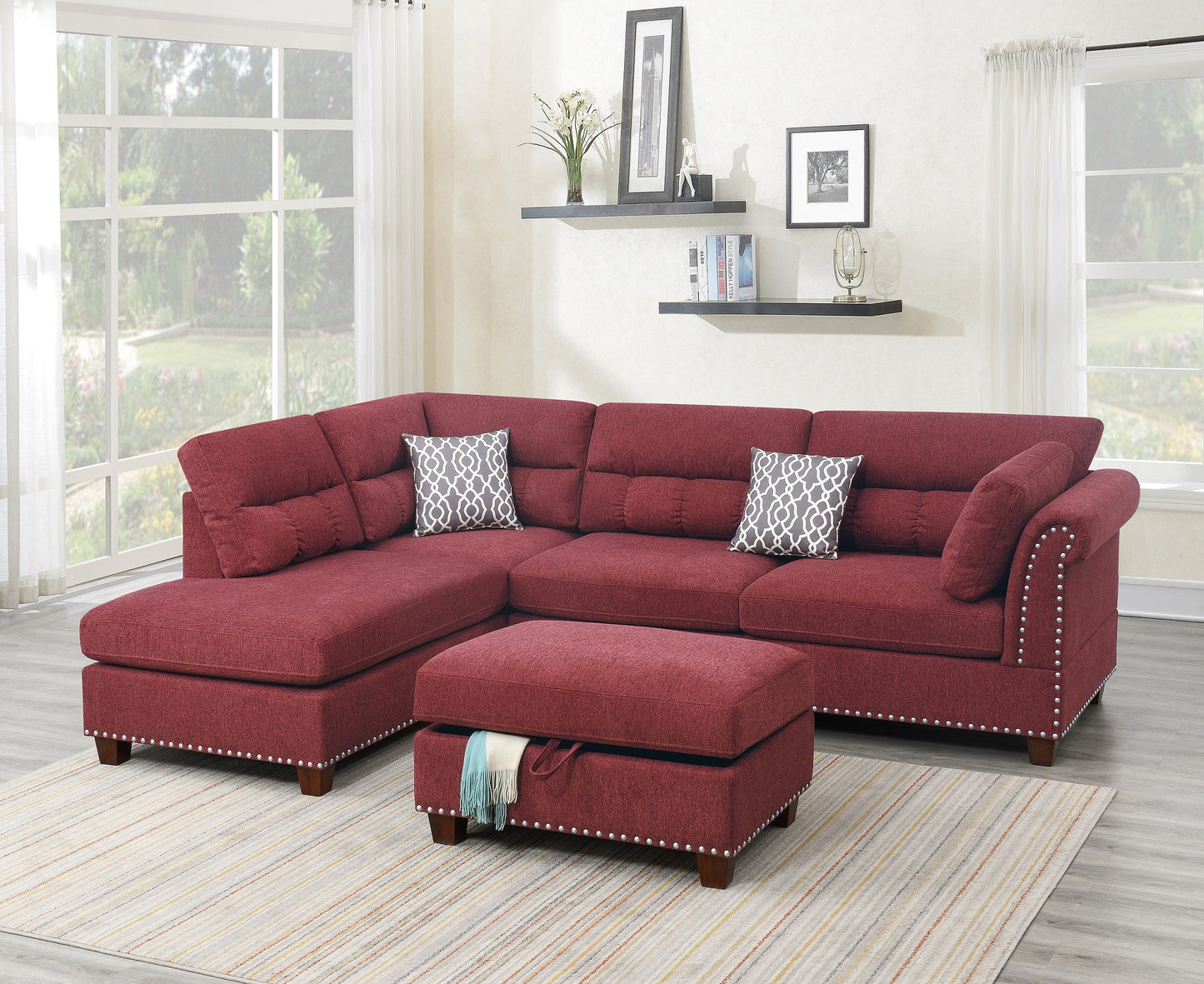 Deep red sectional sofa with decorative nailhead trim and storage ottoman