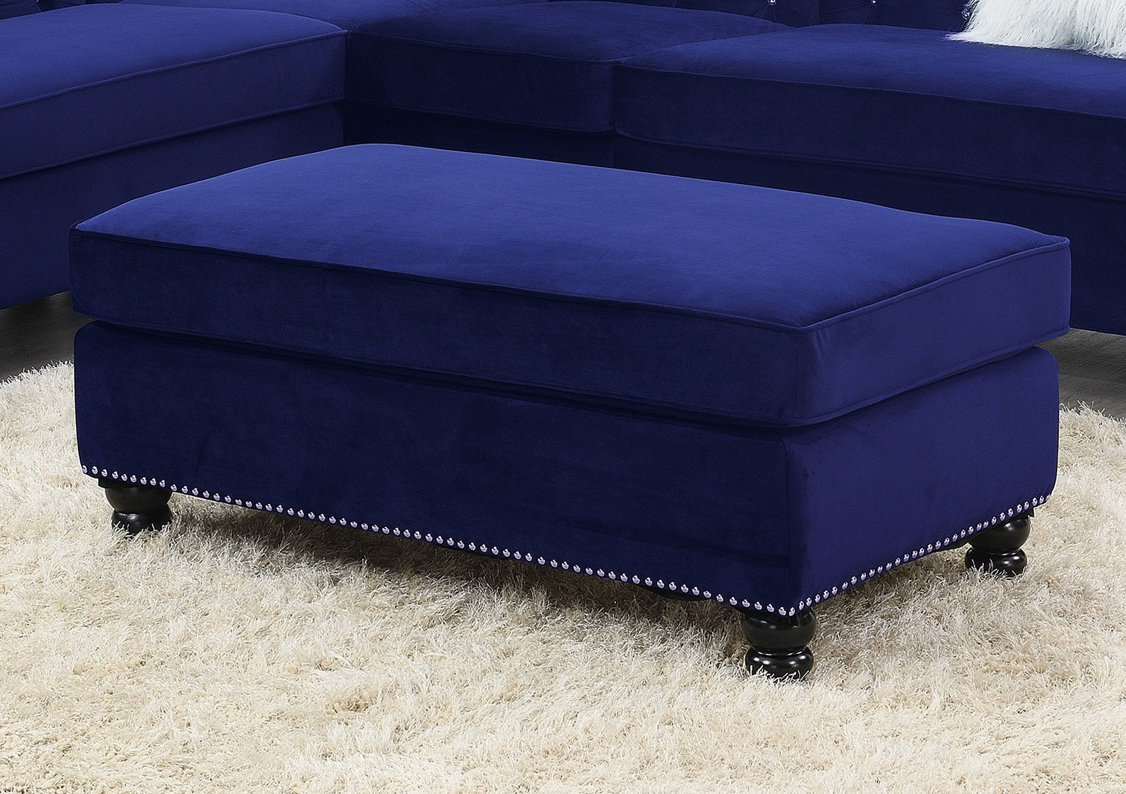 Deep blue velvet ottoman with silver nailhead trim and turned wooden legs