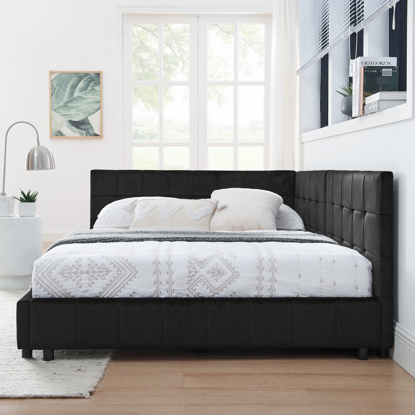 Black velvet tufted corner bed frame with white patterned duvet and pillows