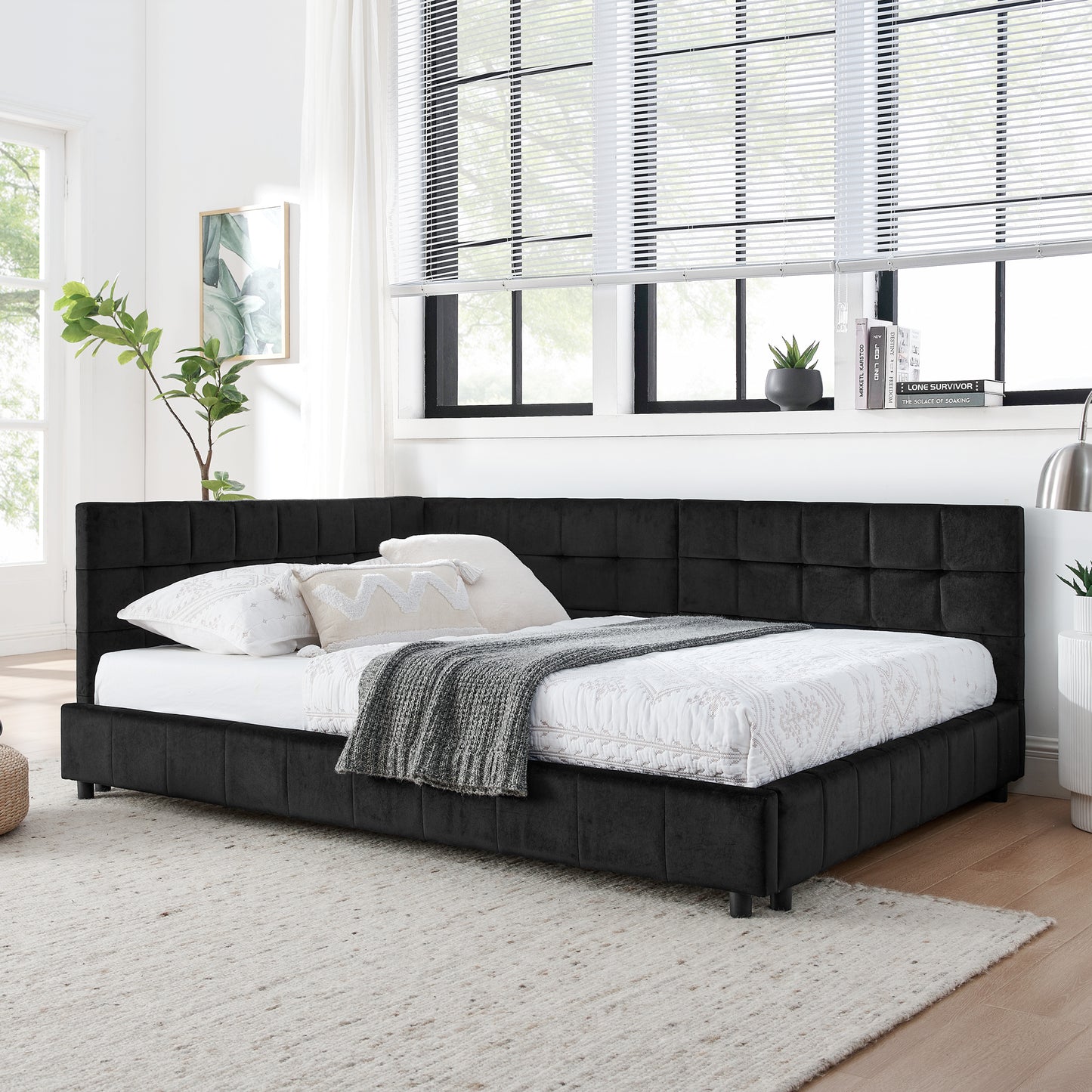 Black velvet daybed with tufted headboard and plush bedding