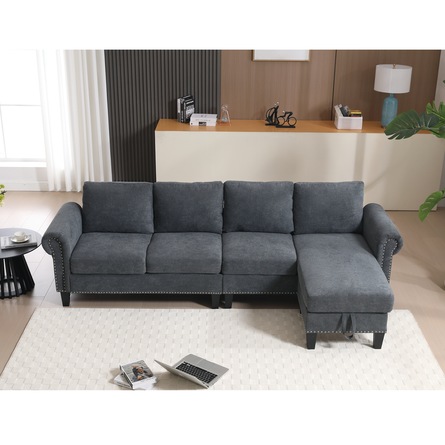 Dark grey upholstered sectional sofa with studded trim and chaise