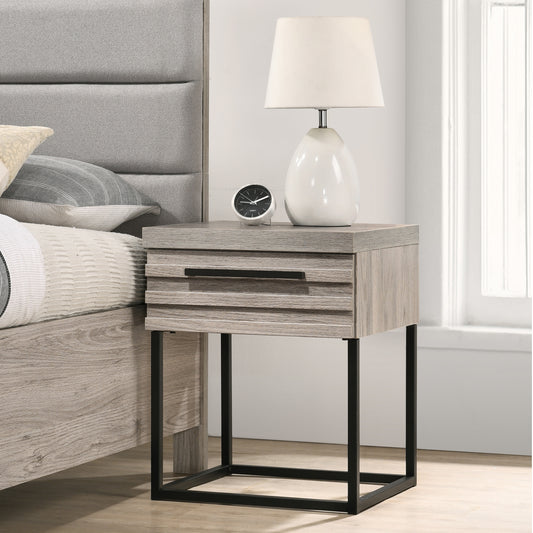 Modern grey wood nightstand with one drawer and black metal legs beside a bed