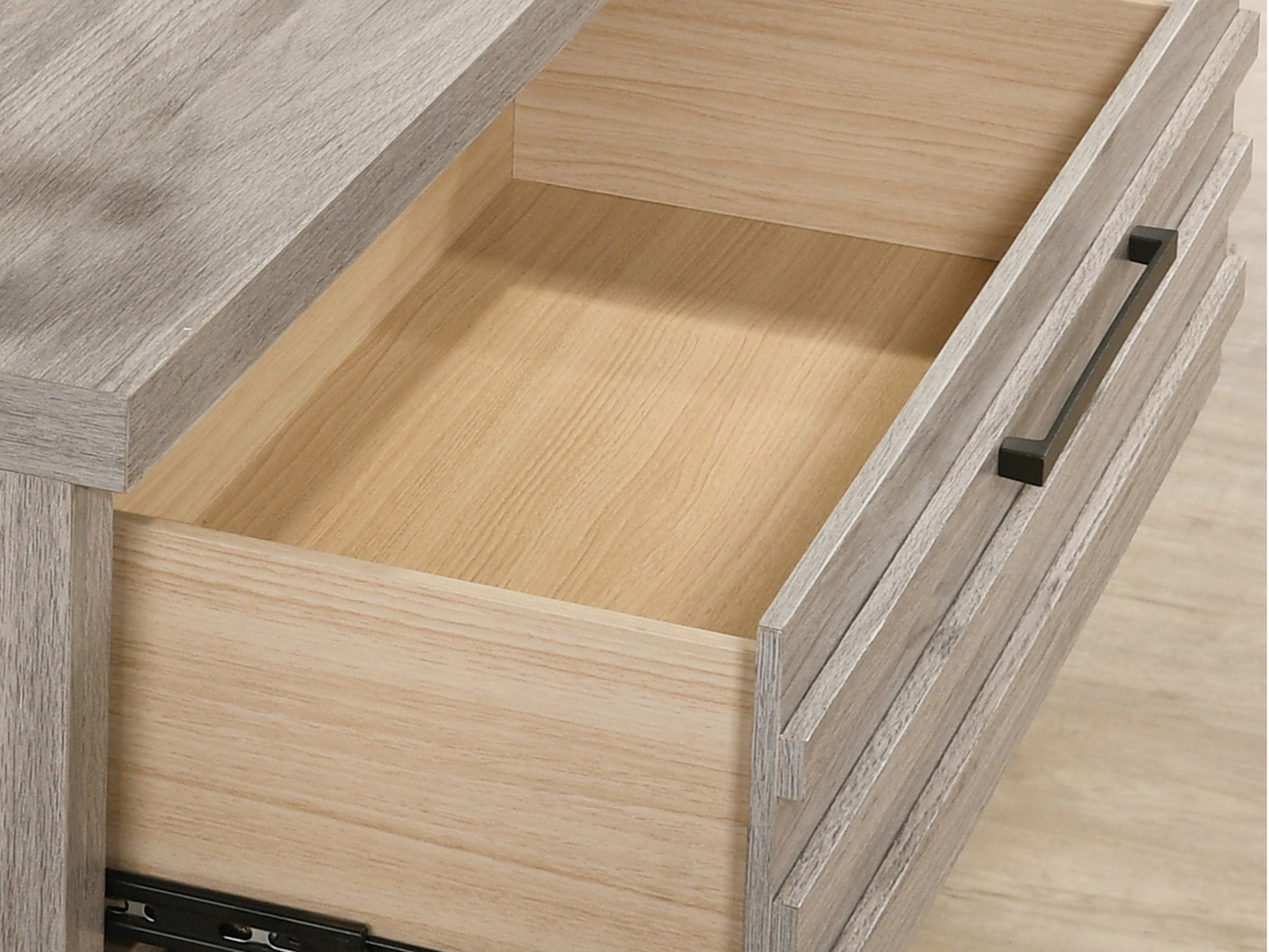 Weathered gray wood drawer front with contemporary black handle part of a dresser