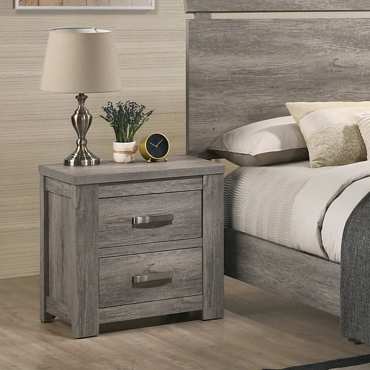 Gray wood nightstand with two drawers featuring silver handles next to a bed