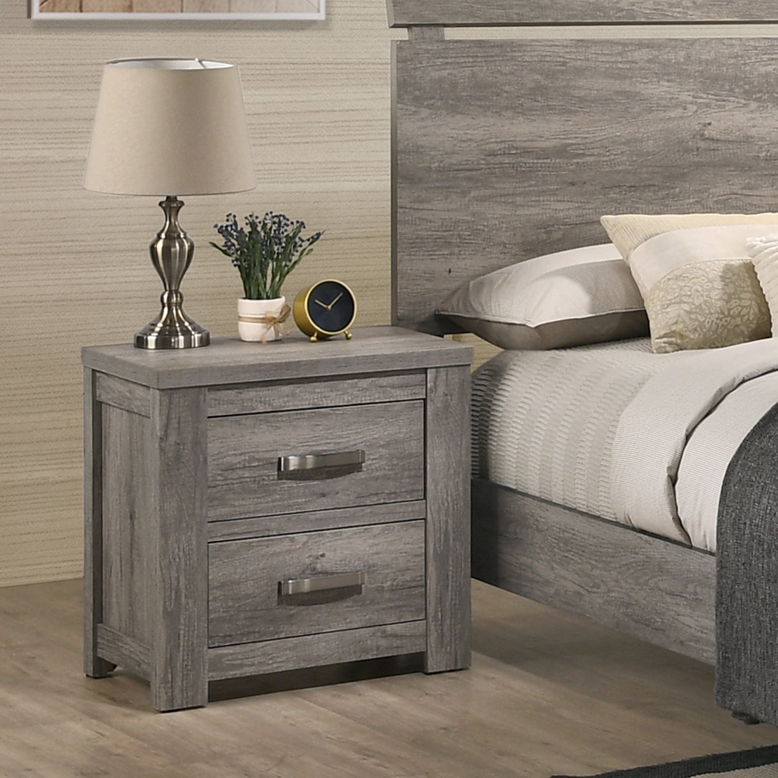 Gray wood nightstand with two drawers featuring silver handles next to a bed