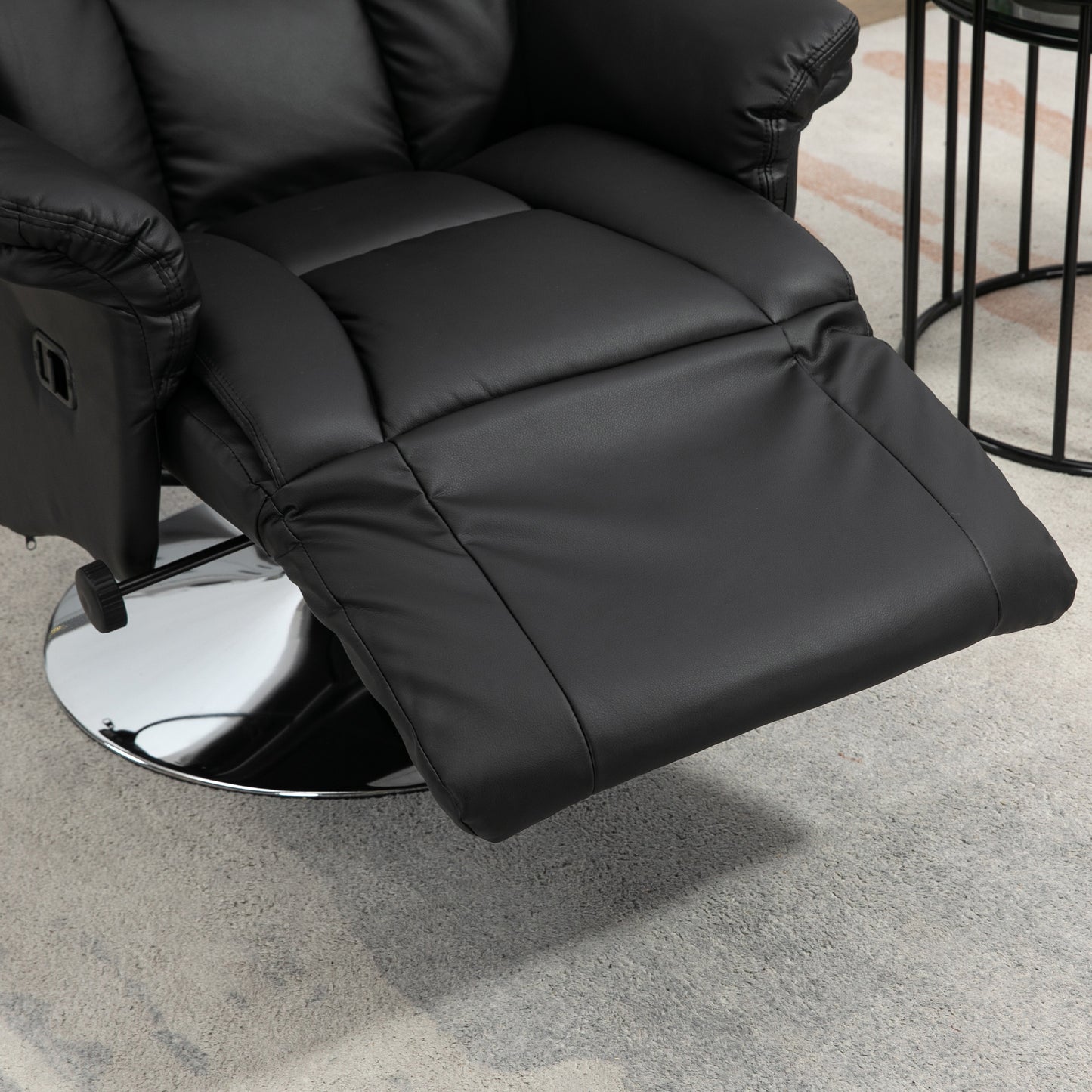 Black faux leather recliner with extended footrest and chrome base