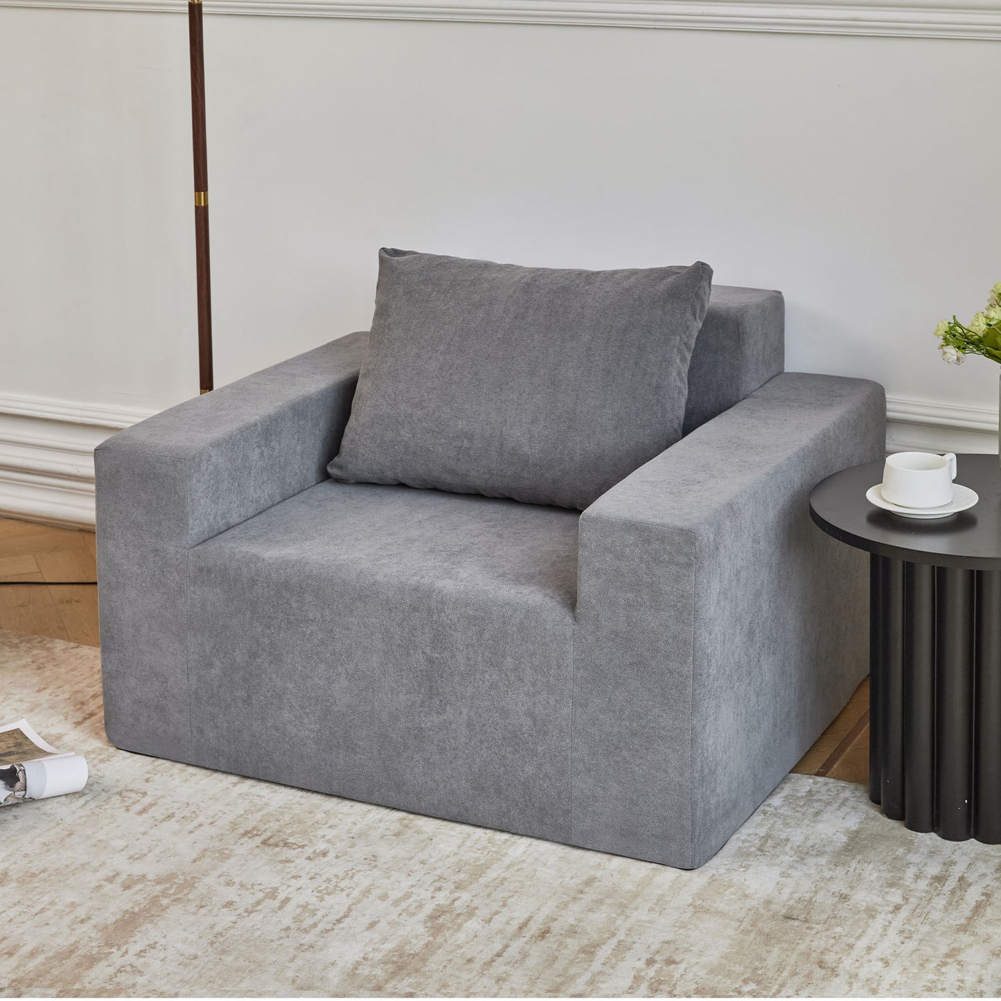 Modern grey fabric armchair with comfortable plush cushion for living room seating
