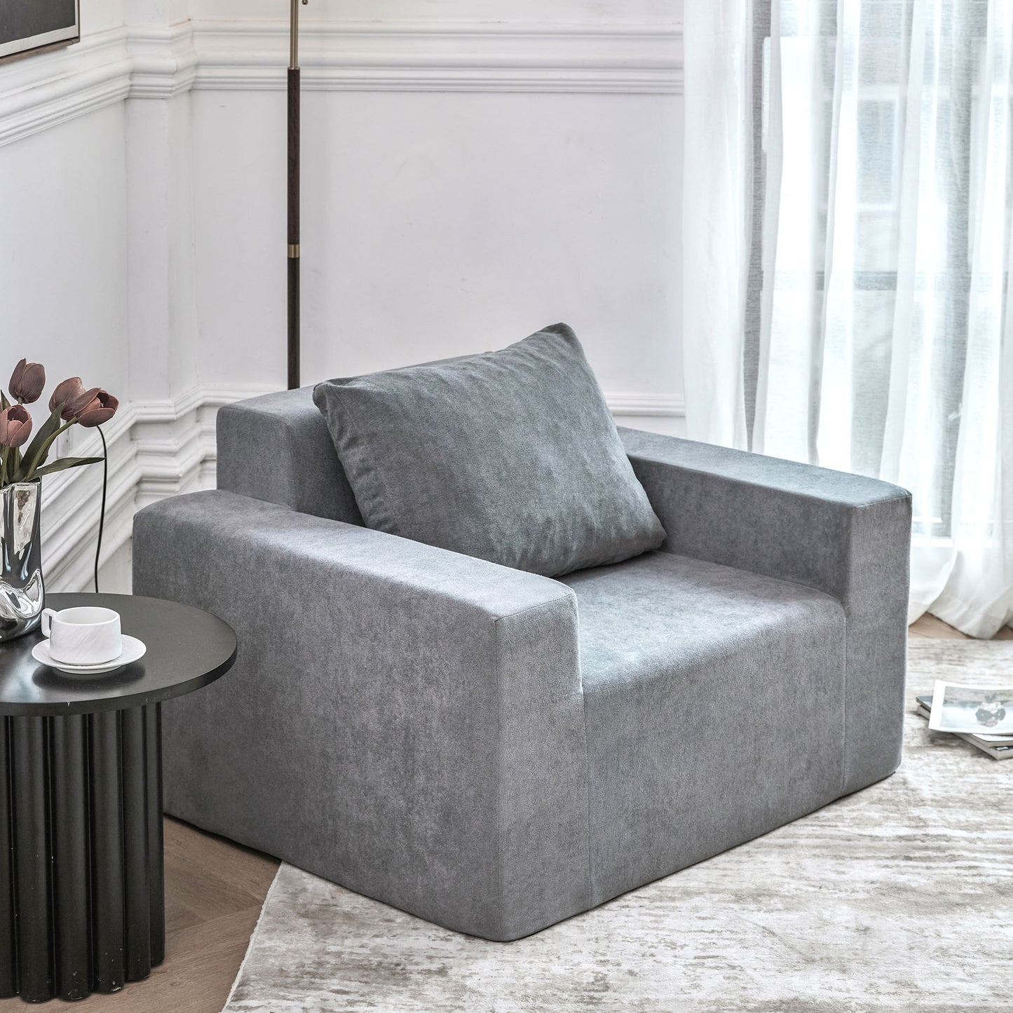 Plush grey fabric armchair with deep seat and plush throw pillow