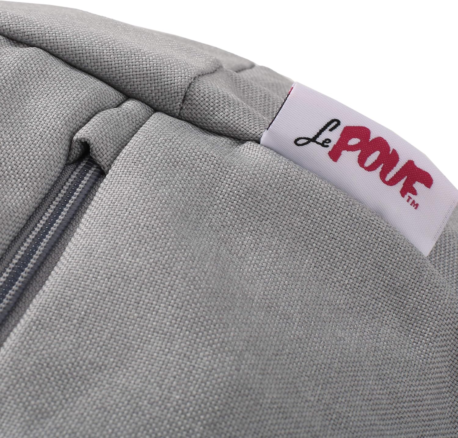 Closeup of a grey linen fabric pouf with a visible zipper detail and a red Le Pouf brand label
