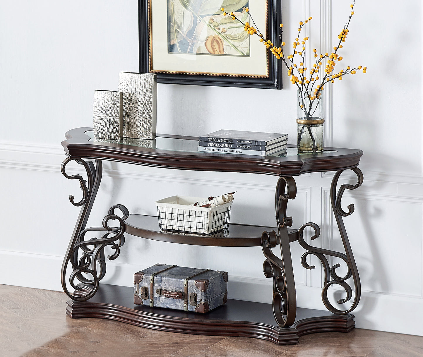 Ornate metal console table with dark wood top and glass shelf displaying decorative items