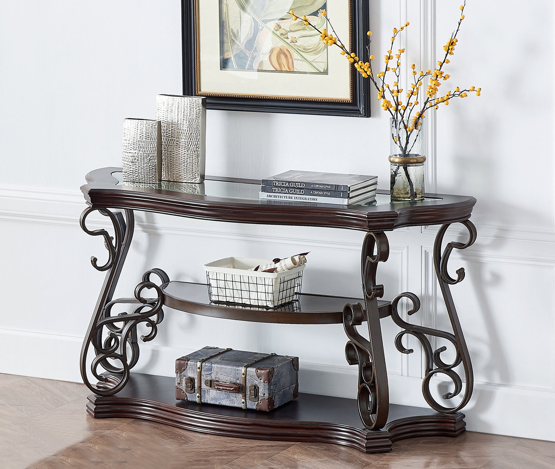 Ornate metal console table with dark wood top and glass shelf displaying decorative items