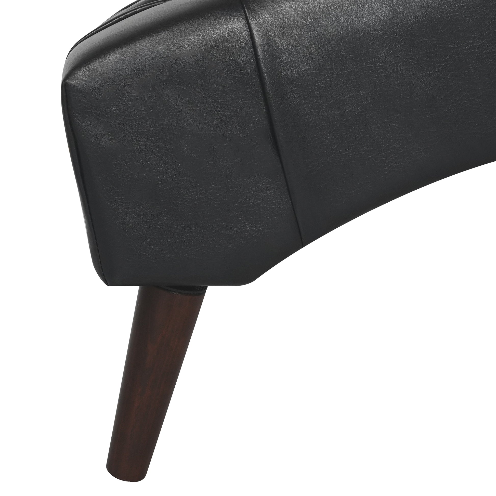 Closeup of black faux leather sofa armrest with tapered dark wood leg detail