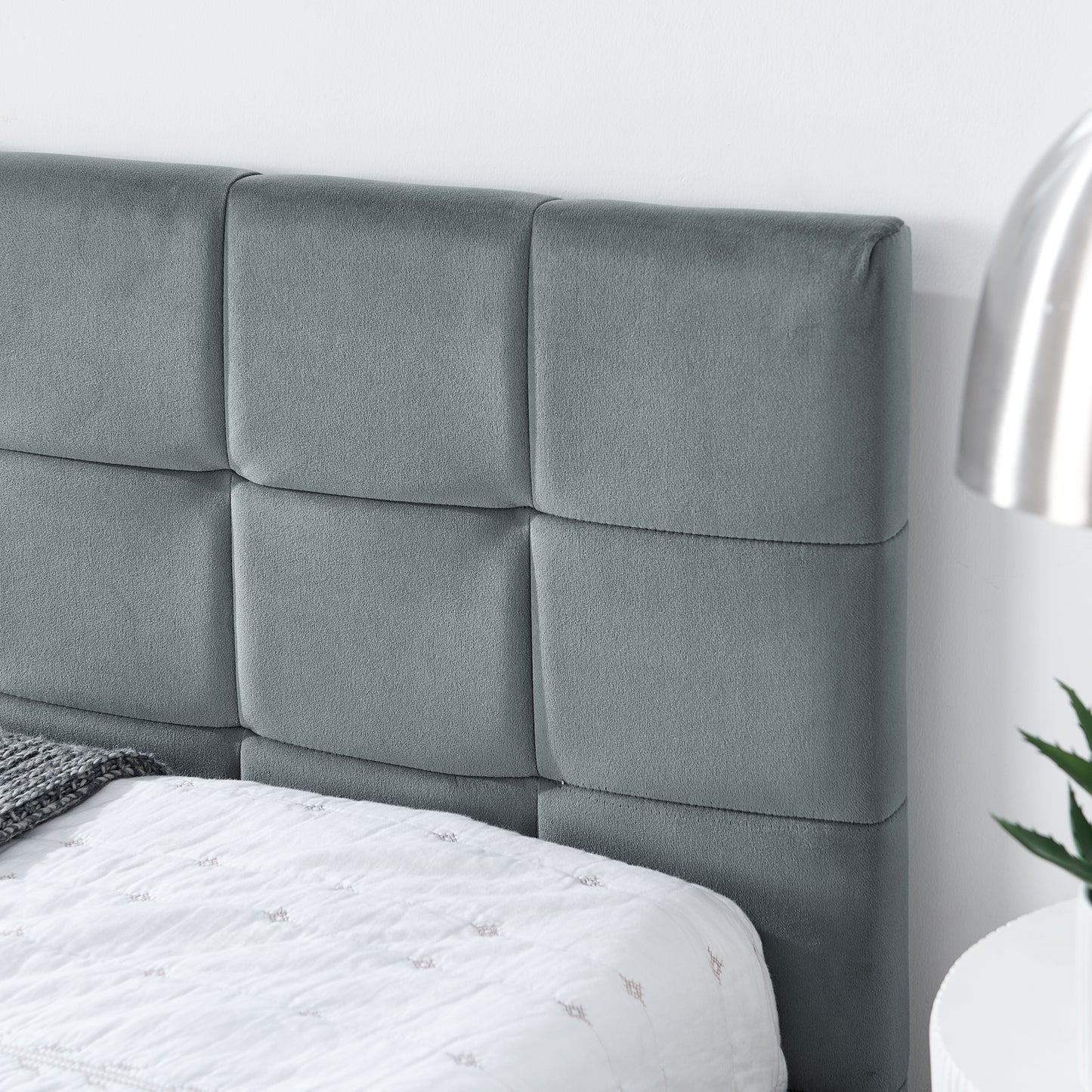 Grey velvet upholstered headboard with tufted squares for a modern bedroom