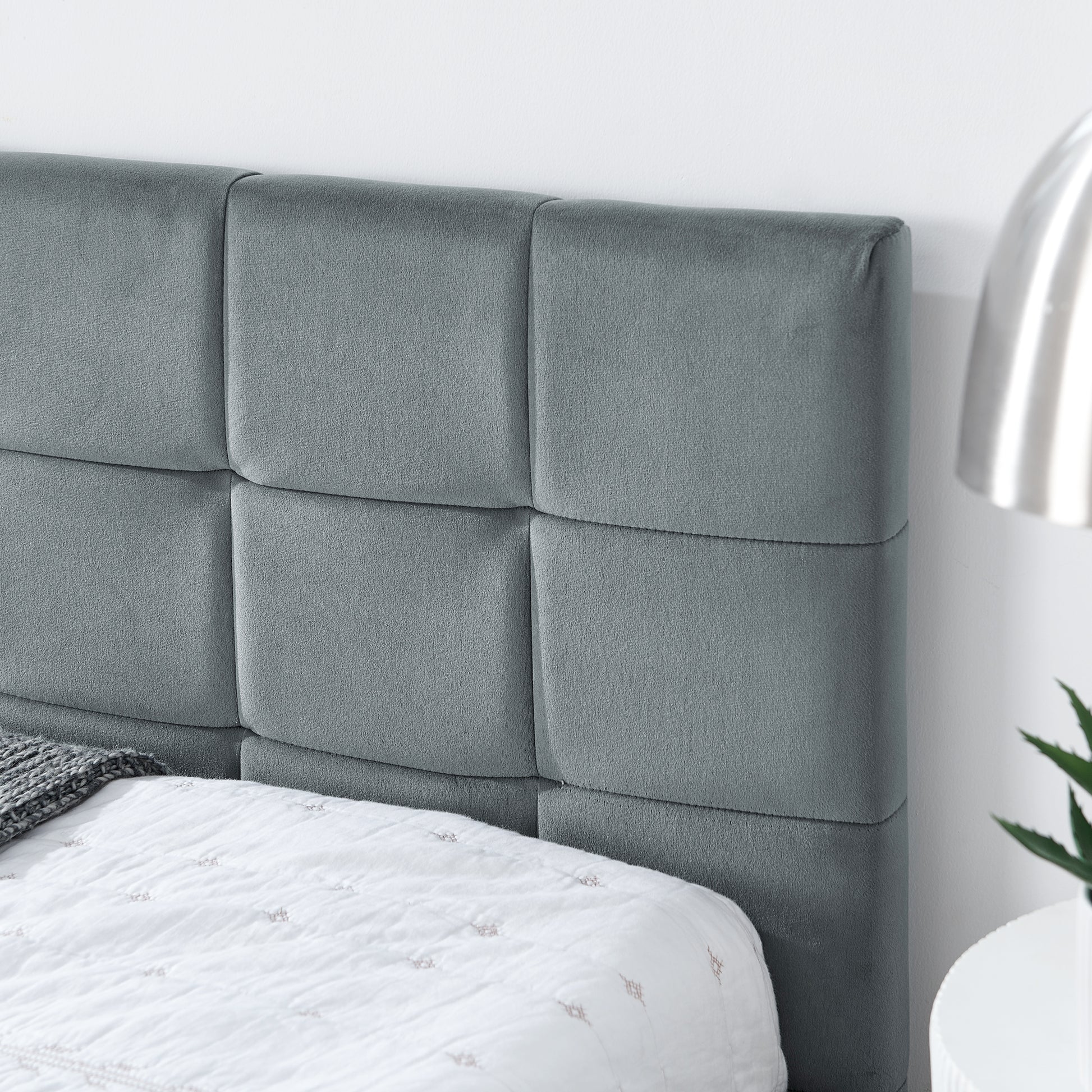 Grey velvet upholstered headboard with tufted squares for a modern bedroom
