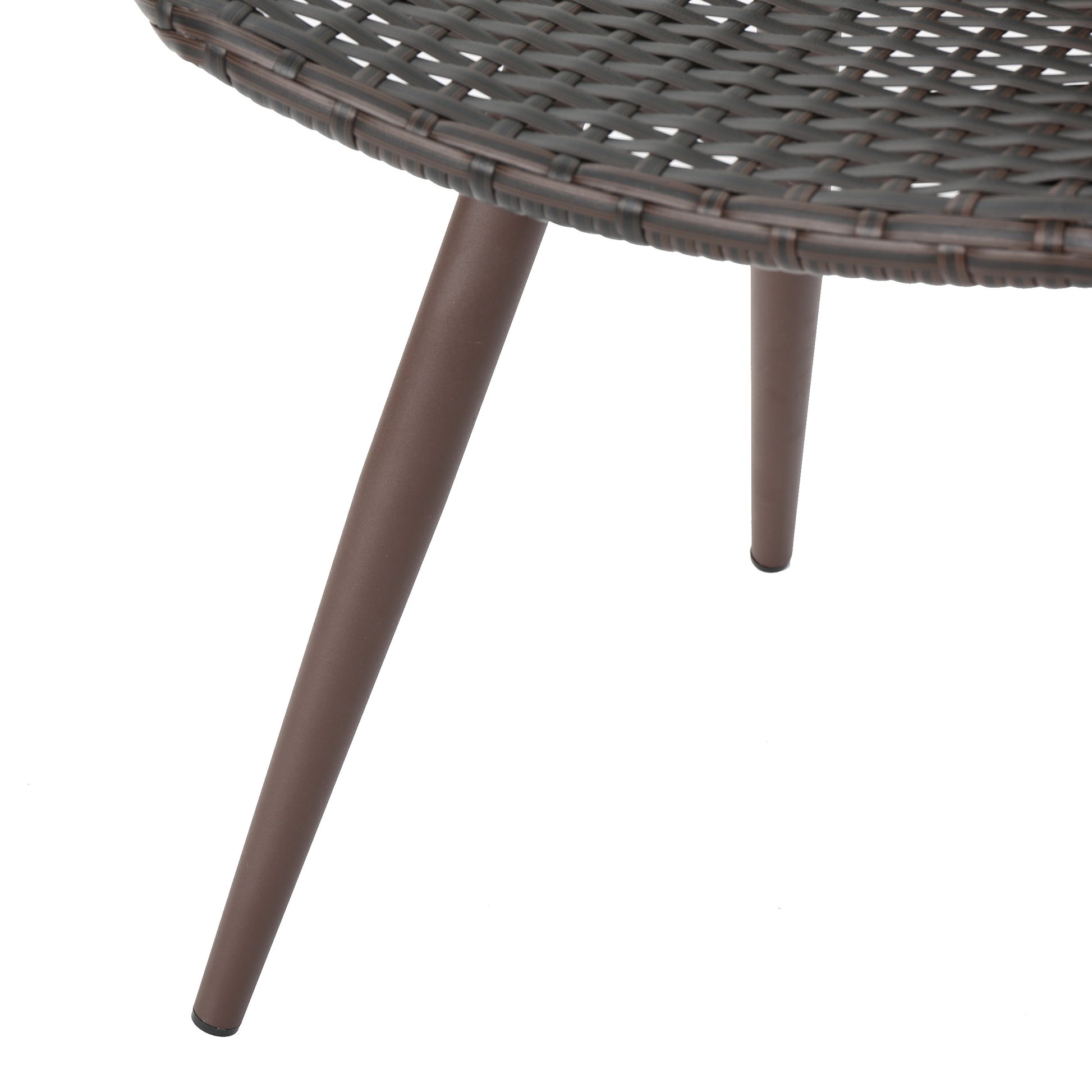 Closeup of dark brown rattan weave on a round table top with three angled brown metal legs