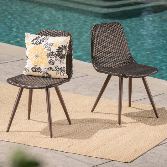 Dark brown rattan patio chairs with floral cushion by poolside