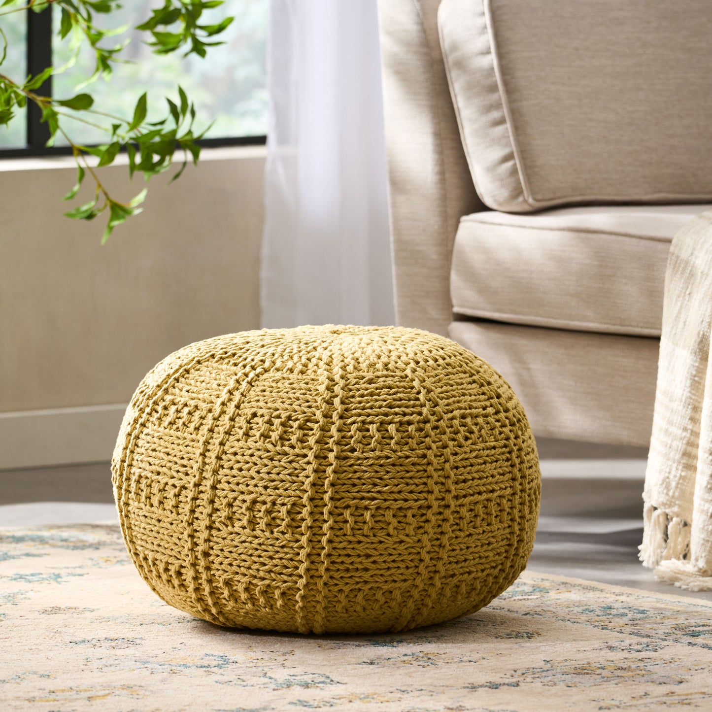 Round mustard yellow knit pouf with intricate texture perfect as footrest or seat