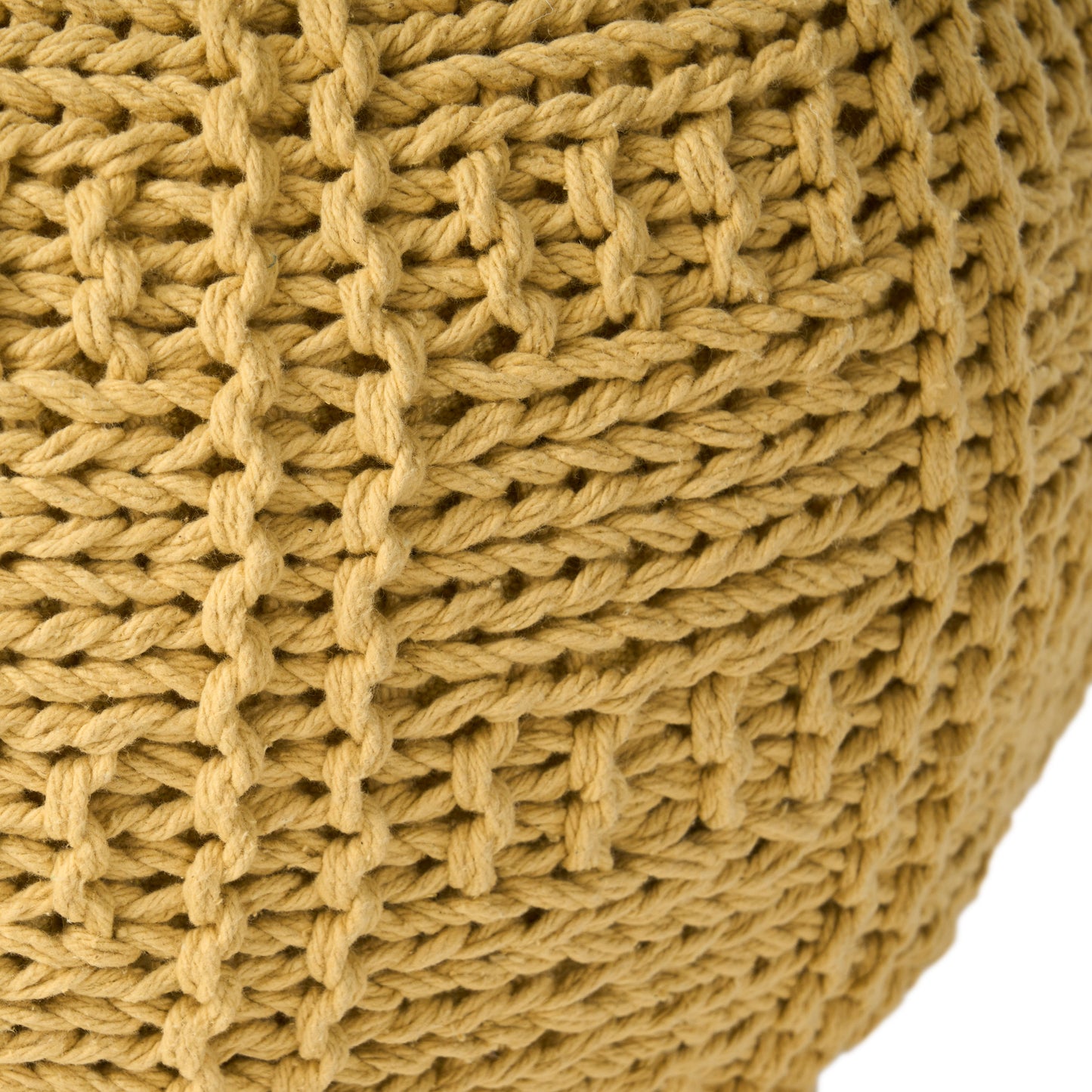 Closeup of a mustard yellow chunky knit pouf with visible yarn texture and open weave