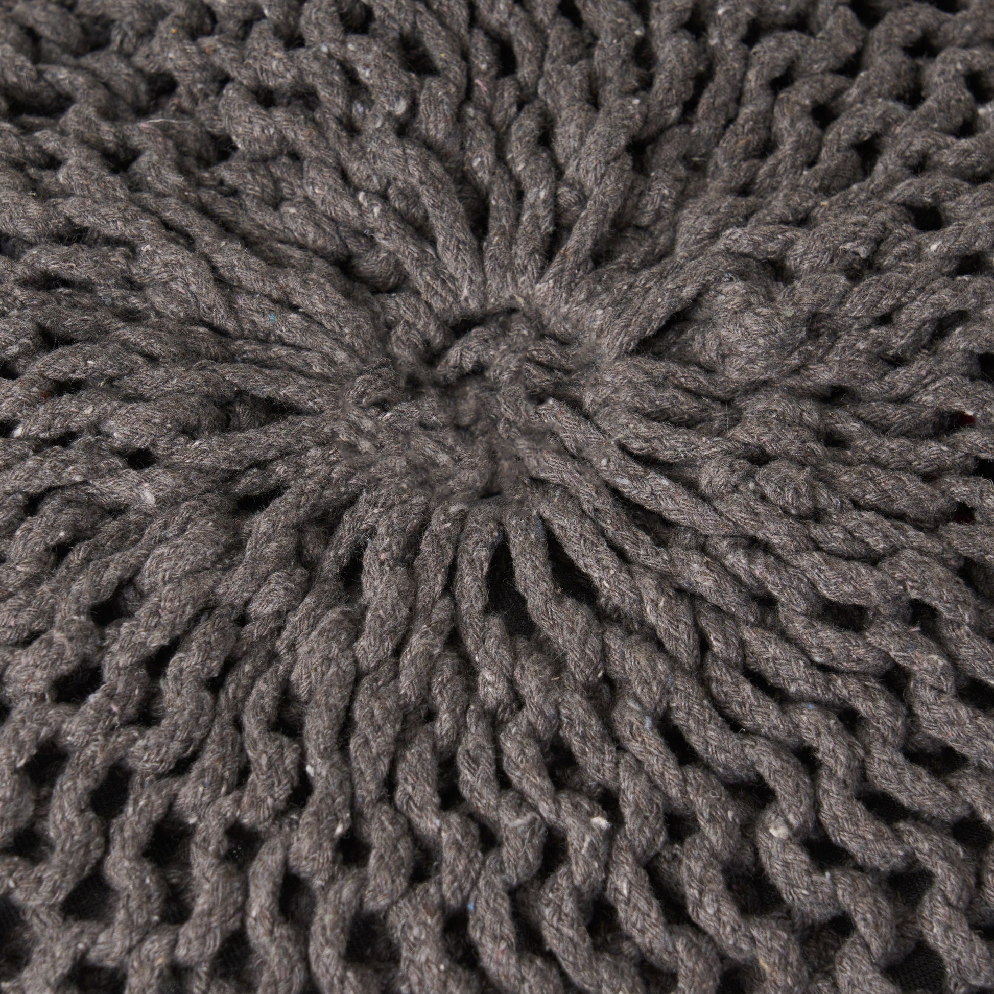 Closeup of thick charcoal grey knit yarn texture with visible loops and stitches