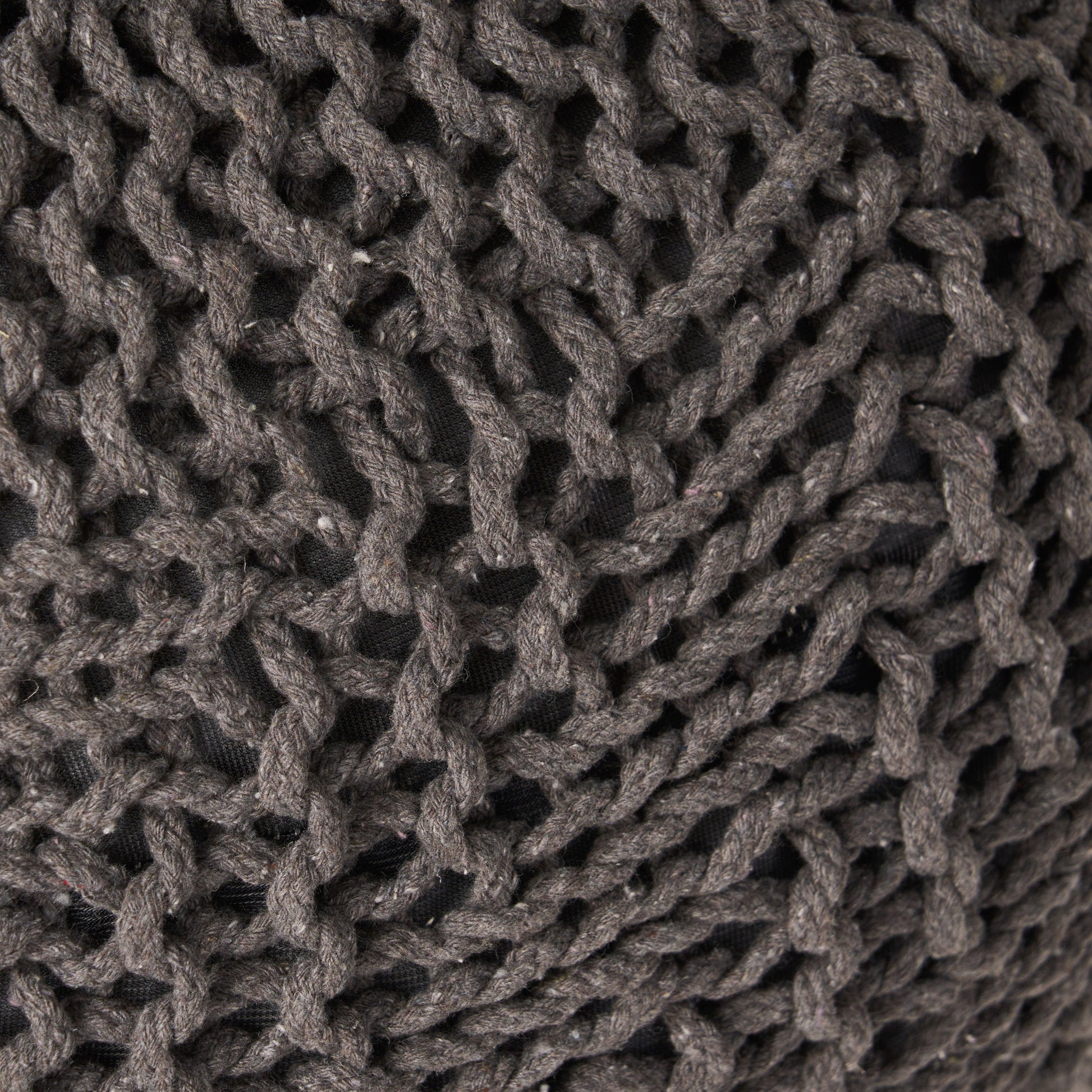 Closeup of a chunky knit grey yarn throw pillow showcasing its textured weave