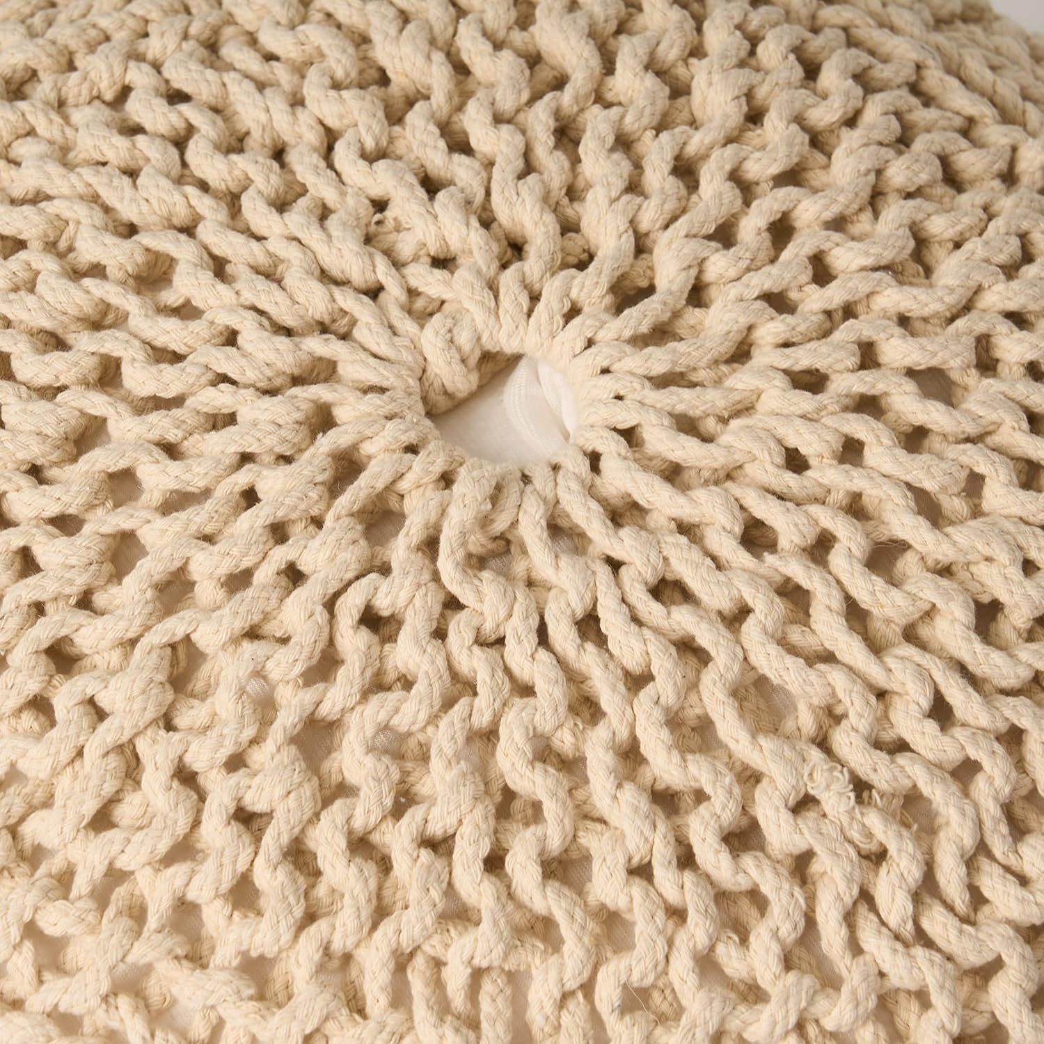 Closeup of a creamcolored chunky knit pouf showcasing textured yarn loops for bohemian decor
