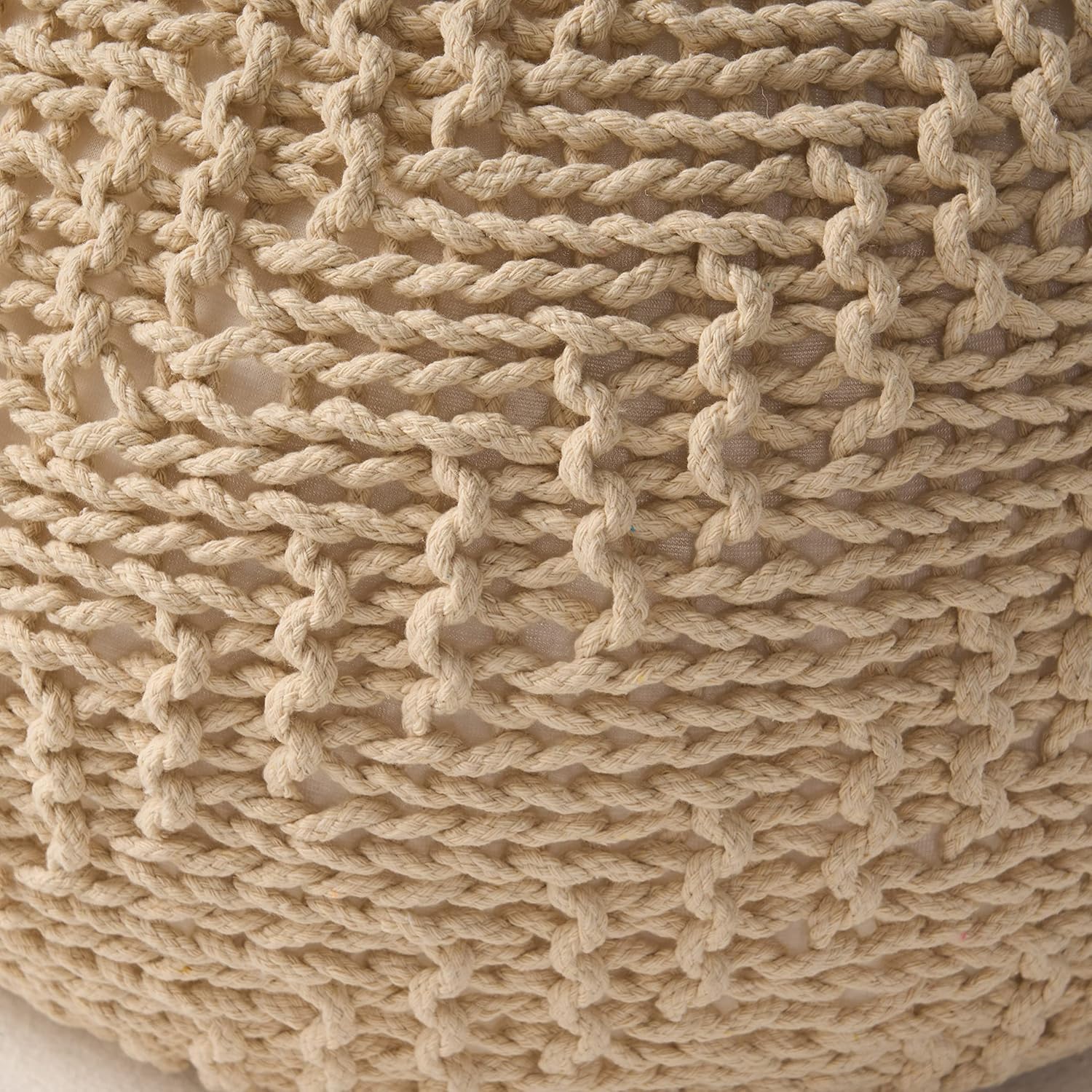 Closeup of a textured beige macrame pouf showcasing intricate knotwork