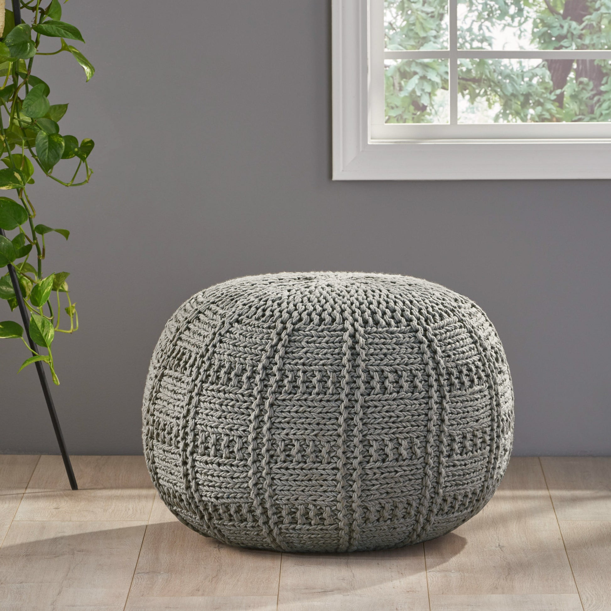 Round grey knitted pouf with diamond pattern texture ideal for footrest