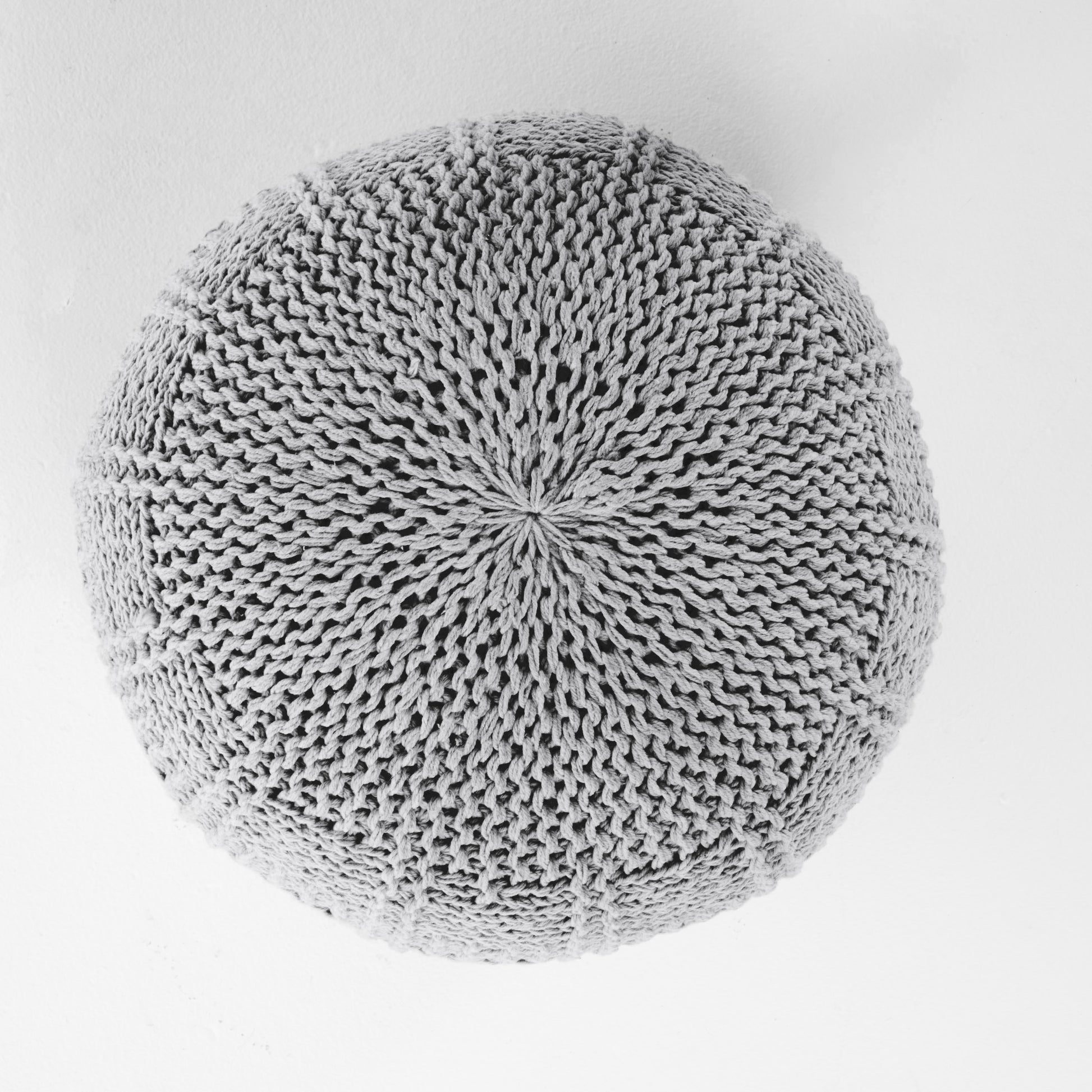 Gray knitted pouf with intricate stitch pattern